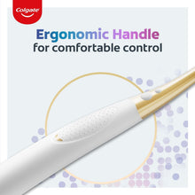 Ergonomic manual toothbrush handle with white grip and small raised dimples, gold collar