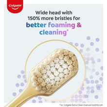 Manual toothbrush with wide head and white bristles, showing foamy cleaning texture