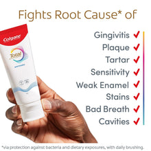 Colgate Total whitening toothpaste tube held in hand with benefits checklist