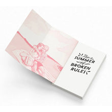 Paperback side view on open pages with pink/blue artwork and “The Summer of Broken Rules”
