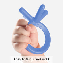 Blue silicone baby teether with three-prong grip held by a hand