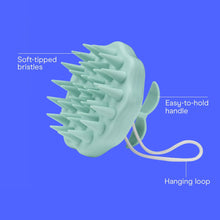 Mint green scalp massager brush with easy-hold handle, soft bristles, and hanging loop