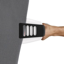Hand using steamer head to press steaming onto dark fabric panel