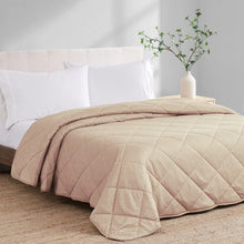 Beige cooling blanket with stitched quilt pattern, neatly draped on bed