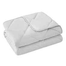 Light gray quilted cooling throw blanket folded with rounded edge