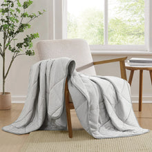 Quilted cooling throw, light gray with stitched channels and draped folds