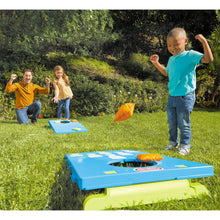 Outdoor kids cornhole game on grass, blue board and orange bean bags