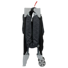 Folded portable baby play yard with dot-pattern fabric and gray wheels