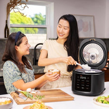 Cosori rice cooker open with steaming inner pot on countertop during meal serving