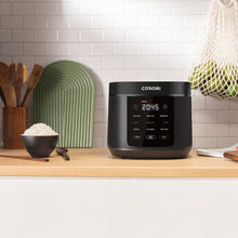 Black Cosori rice cooker on kitchen counter with digital display and black body
