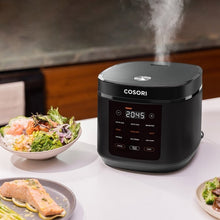 Black Cosori rice cooker on countertop with steam rising from open lid