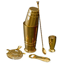 Gold cocktail shaker set with measuring jigger, bar spoon, and citrus strainer