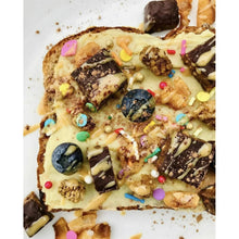 Peanut butter drizzle toast with chocolate pieces, sprinkles, and candy toppings
