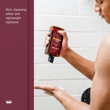 Cremo 2-in-1 shampoo & conditioner bottle in use with hands in shower