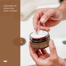 Hands scooping beard & scruff cream from an open jar with cream on fingertips