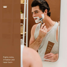 Cremo shave cream tube in hand, brown tube labeled Bourbon Vanilla