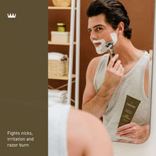 Shave cream applied with white foam on a man’s face, tube held in hand