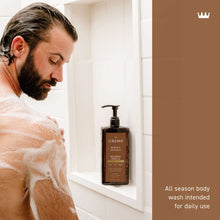 Brown body wash bottle with black pump, shown by a showering man