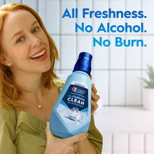 Crest Complete Clean alcohol-free clean mint mouthwash bottle held by smiling woman