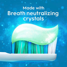 Toothbrush with green toothpaste smear and Crest Clean Breath breath crystals