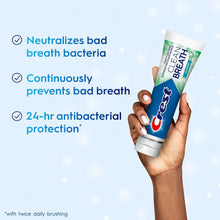 Crest Clean Breath spearmint toothpaste tube held in hand