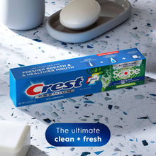 Crest Premium Scope toothpaste box with three mint tubes on speckled surface