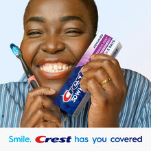 Smiling woman holding Crest 3DWhite Advanced Luminous Mint toothpaste