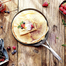 Nonstick crêpe pan holding a cooked crepe with berries on top