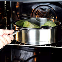 Stainless steel steamer pan in oven with lid open and broccoli inside