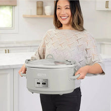 Programmable slow cooker on carry handles, held in front of a person
