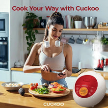 White and red rice cooker on counter beside plated meal