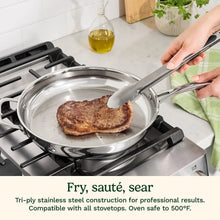 Tri-ply stainless steel skillet with long handle, searing food in pan