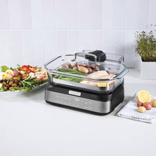 Digital glass steamer with clear lid on countertop, steaming vegetables and mushrooms