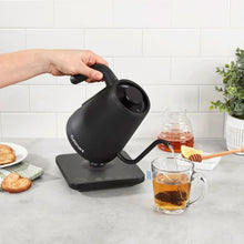 Cuisinart digital gooseneck kettle held by handle, matte black, pouring spout