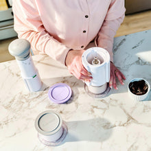 Cuisinart ice cream maker with multiple half-pint cups, opened top, and lids