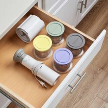 Cuisinart ice cream maker parts and four half-pint cups in kitchen drawer