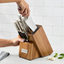 Wooden knife block holding several stainless steel knives