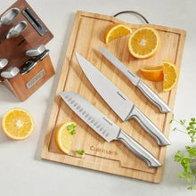 Stainless steel knife set with three knives on wooden cutting board