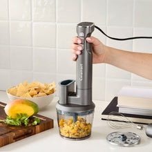 Hand-held immersion blender over chopper cup with lid and countertop accessories