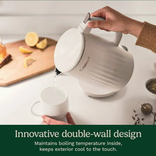 Cuisinart electric kettle pouring into a cup, white body and curved handle