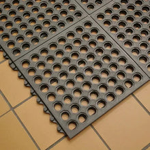Interlocking rubber mat tiles with circular holes, dark gray, corner section