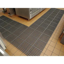 Modular floor mat tile with circular holes in dark gray, rectangular coverage