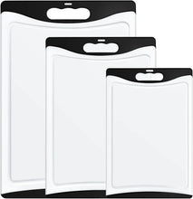 Set of 3 white plastic cutting boards with black handles, nested for storage