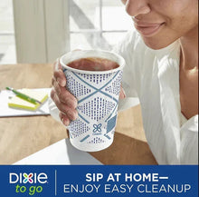 Insulated paper cup with domed lid, blue geometric pattern, held for sipping