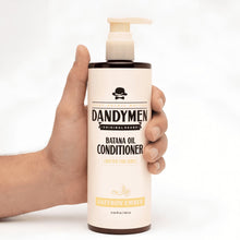 Hand holding Batana oil conditioner bottle with pump, Saffron Ember label