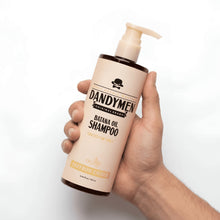 Hand holding hydrating shampoo bottle with pump, beige Saffron Ember label