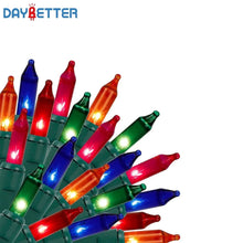 Multicolor Christmas string light bulbs on green base with glowing tips
