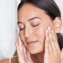 Face oil application: person massaging cleansing oil on cheeks and temples