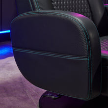 Black gaming chair armrest pad with teal contrast stitching along the edge