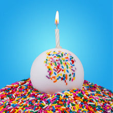 Spherical bath bomb with colorful sprinkles and small flame on top